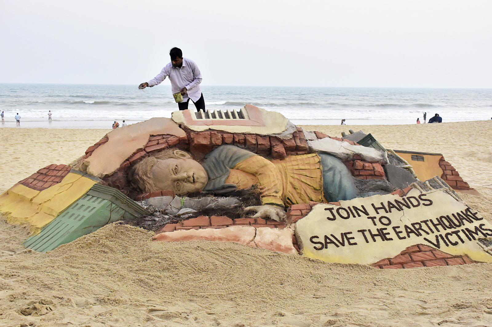 Sand artist Sudarsan Pattnaik creates a sand sculpture in tribute to the victims of the earthquakes that hit Turkey and Syria