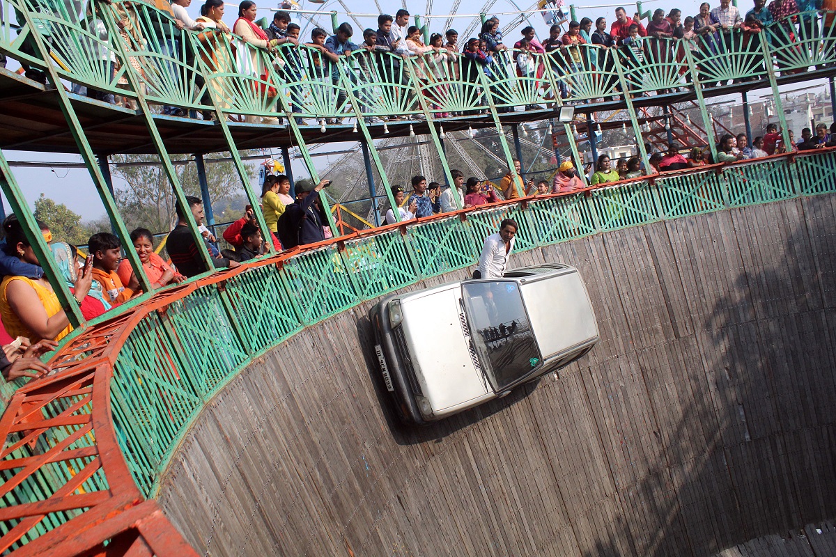 Maha Shivaratri festival: A stunt performer ride a car in the well of death at a fair