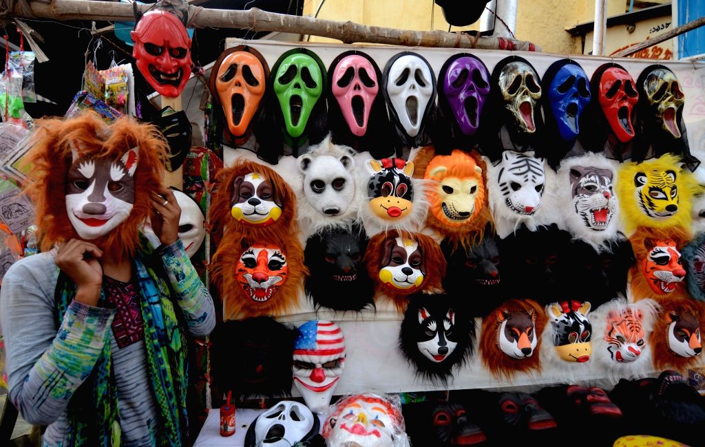 A vendor sells mask at a Burrabazar ahead of Holi festival