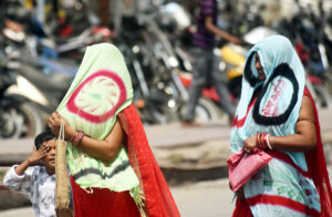 Women cover their heads with stoles to protect themselves on hot summer day