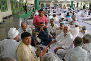 Farmers smoke hukkah during a Khap panchayat members meeting on wrestlers’ protest in Kurukshetra