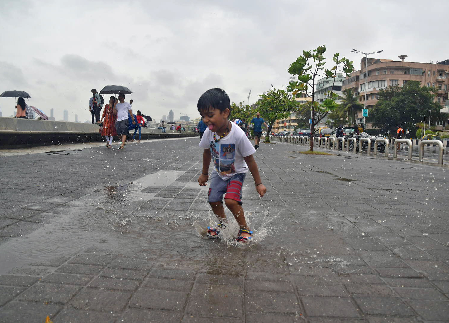 A child enjoys rainy weather in Mumbai