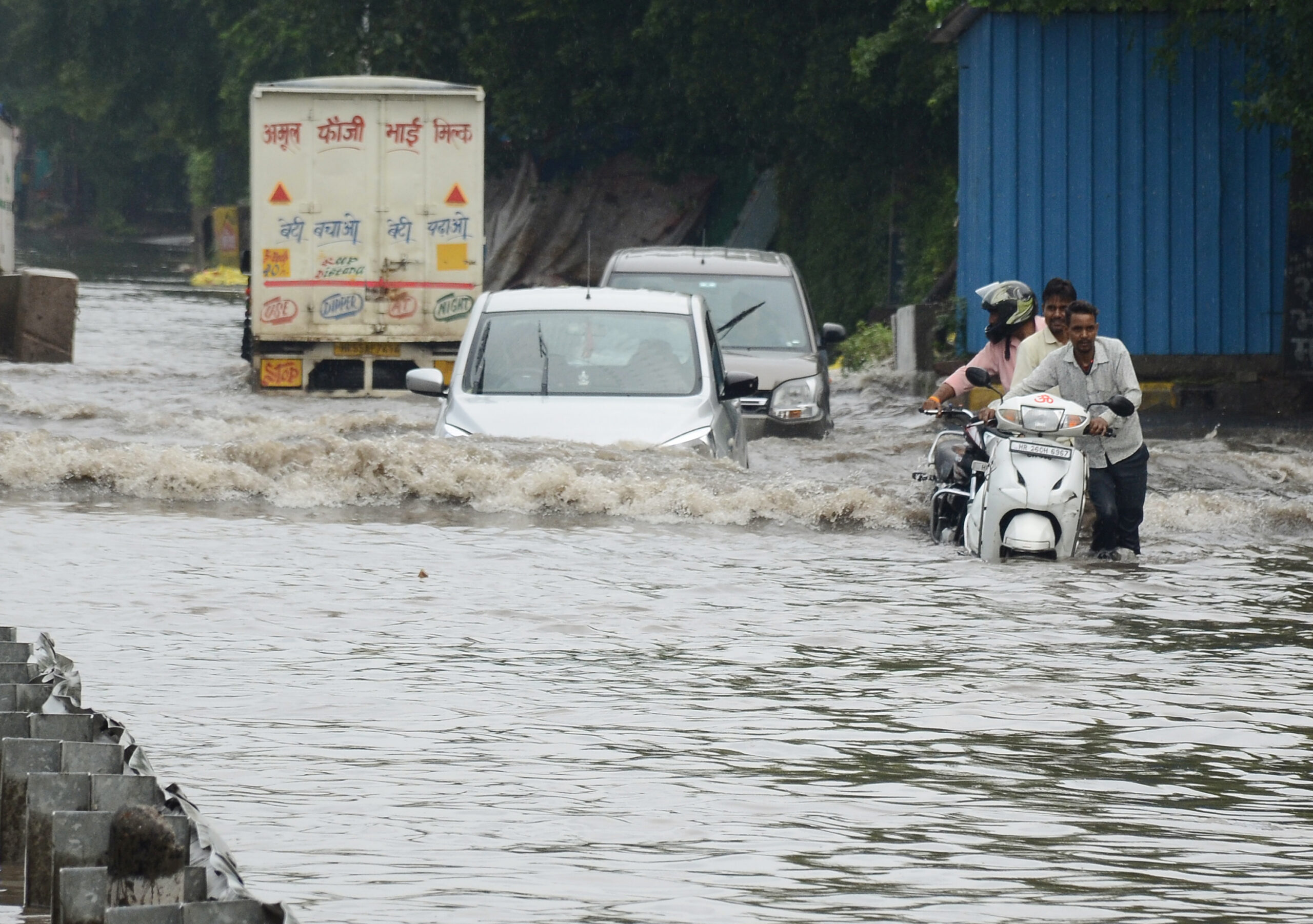 Commuters wade through the waterlogged streets