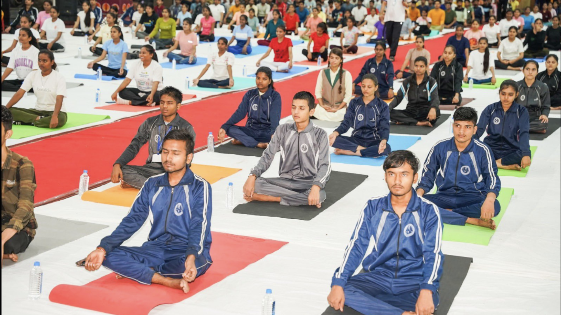 CM Yadav performing Yoga asanas alongside students and special guests.