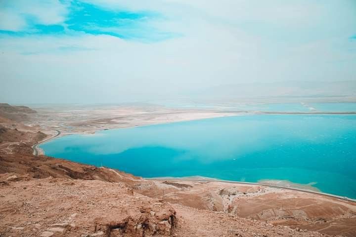 The Dead Sea’s shore with people floating effortlessly in its salty waters. - Photo Gallery