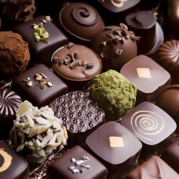 A box of assorted Belgian pralines each filled with decadent chocolate flavors. - Photo Gallery