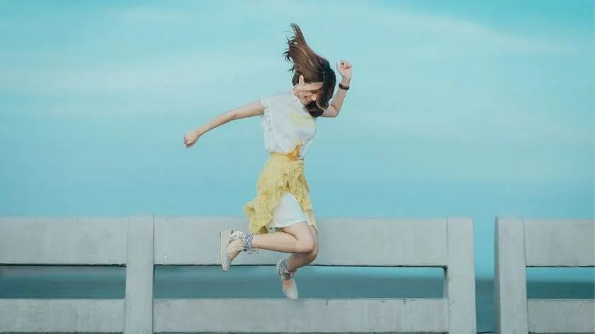 Image of woman jumping happy with the blessings of angel number 420 in numerology 