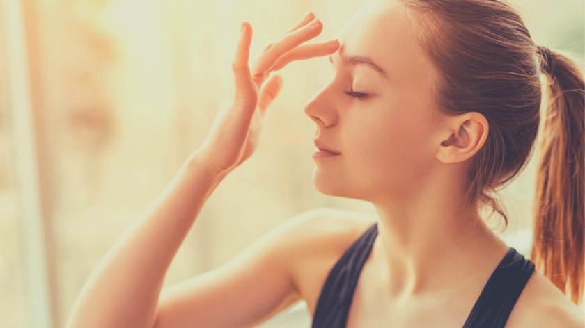 Woman touch third eye area of forehead