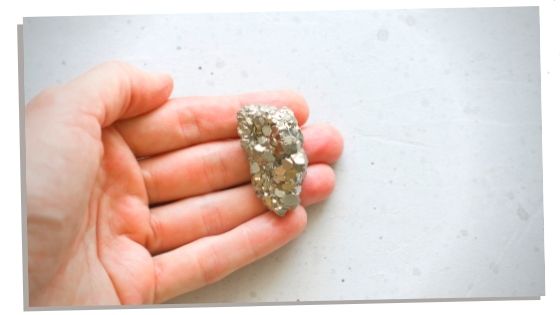 Hand holding healing Pyrite