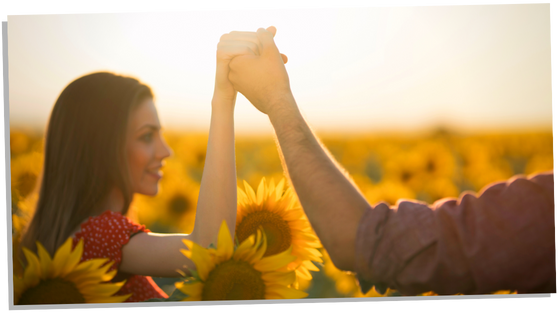 Soulmate couple holding hands in a sunflower field