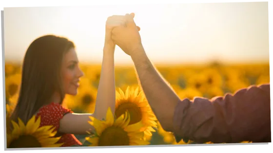 Soulmate couple holding hands in a sunflower field