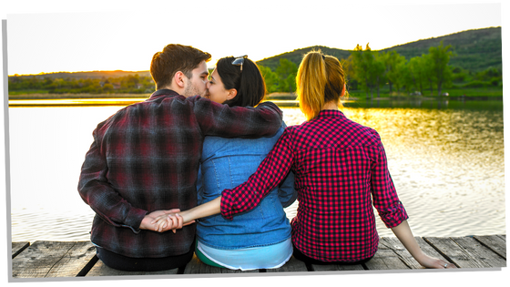 Man holding hand with another woman behind his girlfriends back