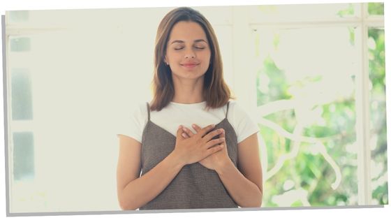 Image of a woman experiencing a physical symptoms of her heart chakra opening