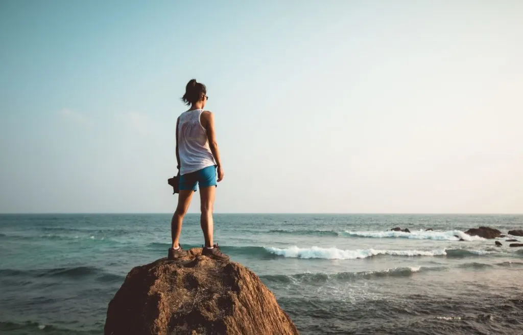 Woman standing tall on a rock