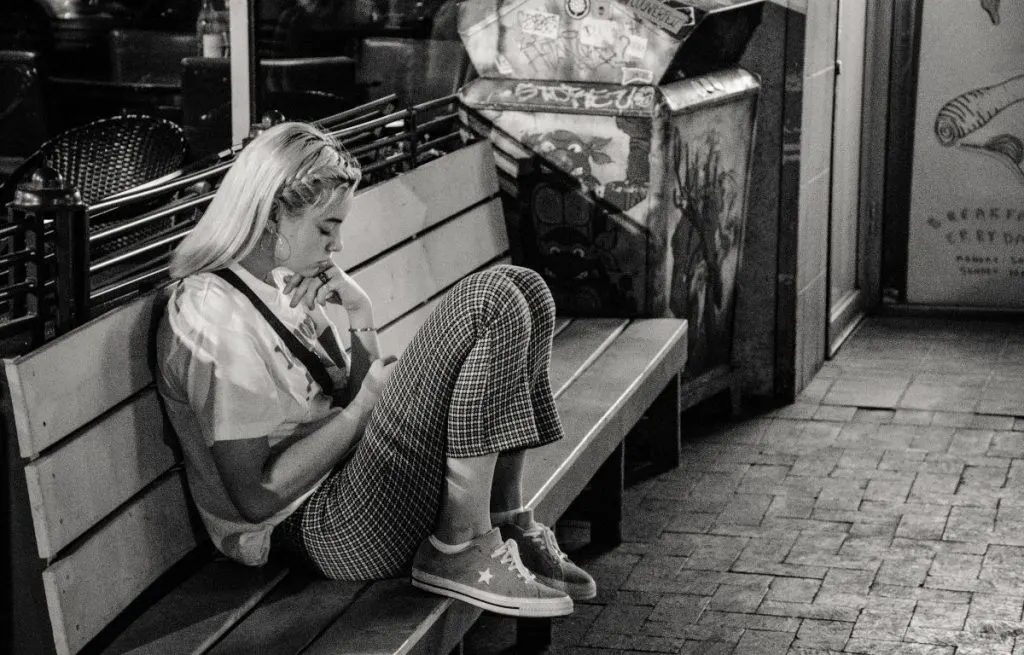 Woman sad on bench feeling unnoticed by partner