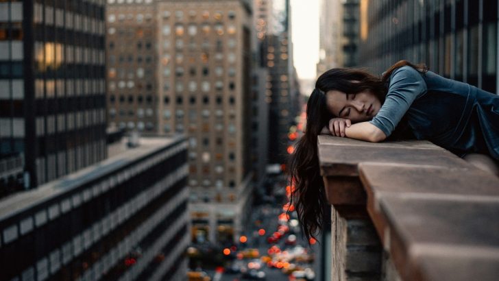 woman leaning on top building rail during daytime